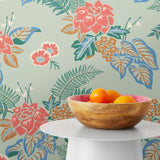 Our Lanai wallpaper is inspired by the rich tradition and exuberant patterns of Hawaiian shirts, with a twist. Highly durable, fade resistant, and made in the USA. This wallpaper features pink flowers with green and blue leaves on a mint green background and was created in collaboration with The Aesthetics of Joy.