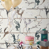 Balancing Act (Cream) wallpaper features colorful dancing monkeys and rabbits on a cream background