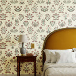Chance (Punch) wallpaper features intricately illustrated flowers and herbs in green and pink on an off white background.