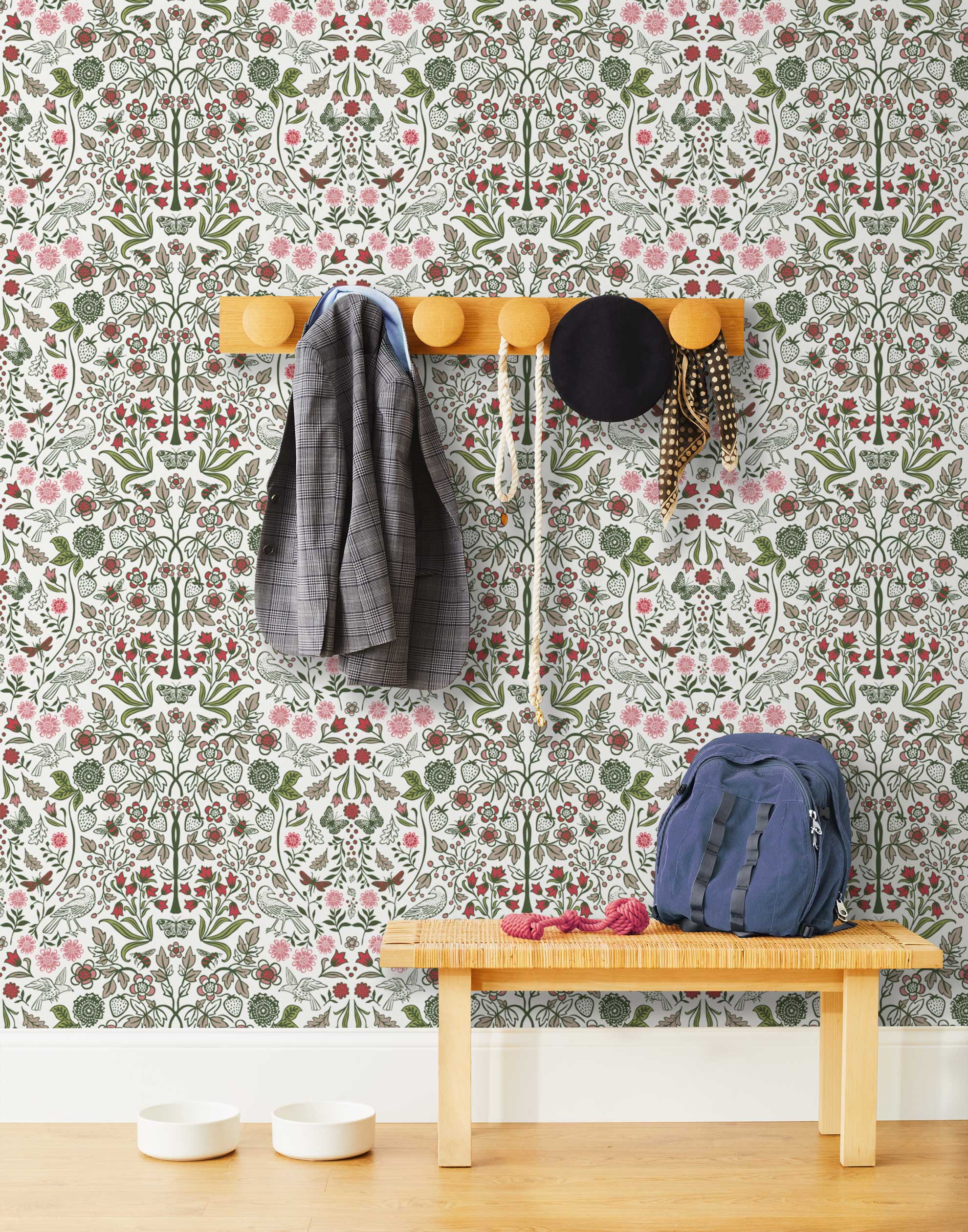 Nora (Leaf) wallpaper features a garden of bees, birds, strawberries, and flowers in shades of green, pink and taupe on a white background.