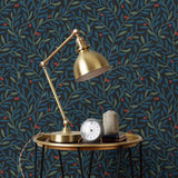 Olive Grove (Ebony) featuring a leafy vine motif in shades of green and blue with deep red accents on a black background | Schoolhouse x Hygge & West Wallpaper Collection