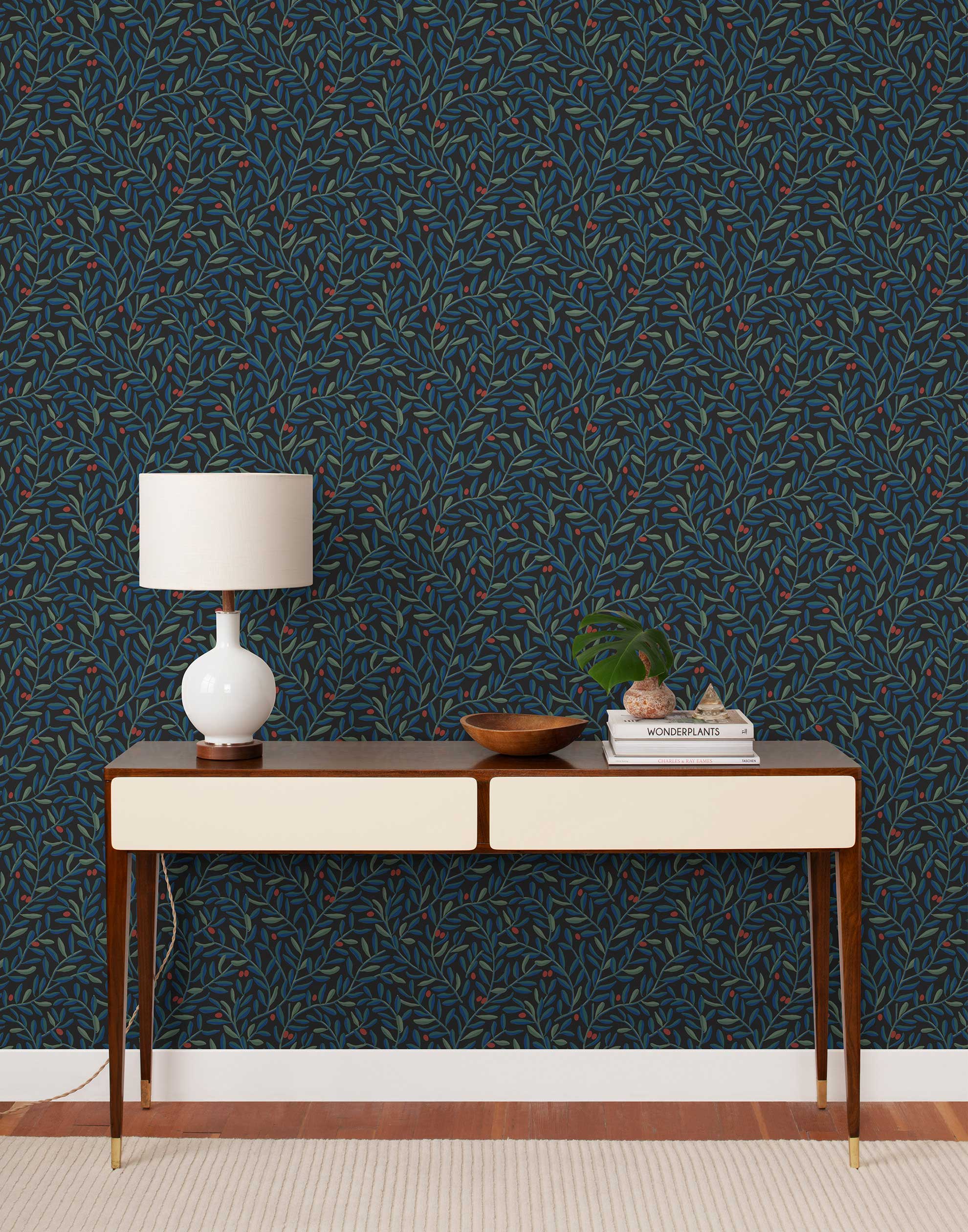 Olive Grove (Ebony) featuring a leafy vine motif in shades of green and blue with deep red accents on a black background | Schoolhouse x Hygge & West Wallpaper Collection