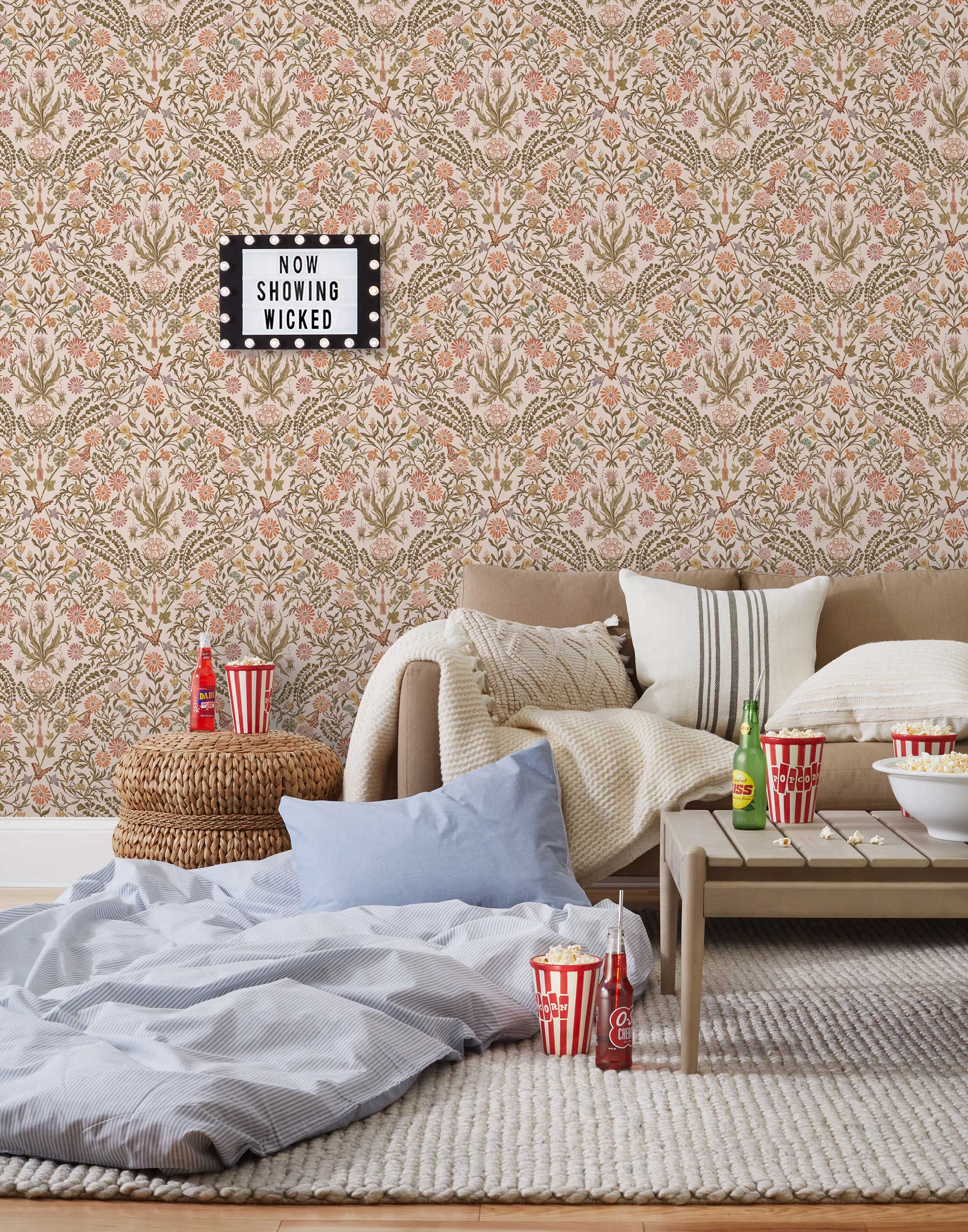 Inspired by the painted ceiling of Glinda and Elphaba's Shiz University dorm room in the movie Wicked, this wallpaper features colorful flowers and a crown on a soft pink background.