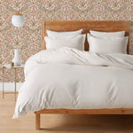 Inspired by the painted ceiling of Glinda and Elphaba's Shiz University dorm room in the movie Wicked, this wallpaper features colorful flowers and a crown on a soft pink background.