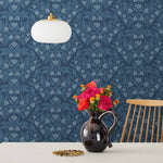 Symmetry wallpaper is a stylized floral wallpaper and designed in linocut style by Katharine Watson for Hygge & West | Light blue flowers on a navy blue wallpaper background.