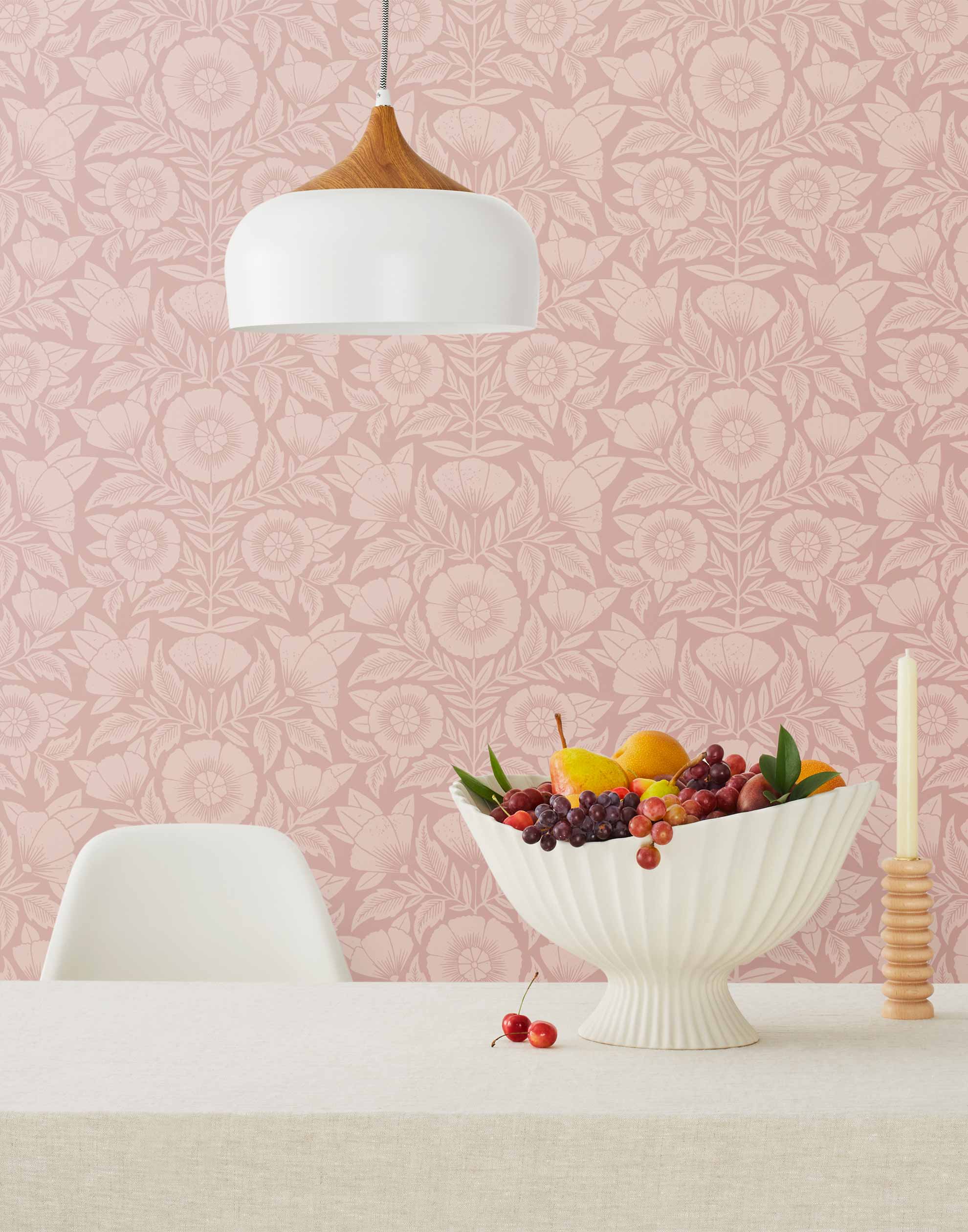 Conservatory wallpaper featuring stylized petals and leaves dervived from a block-print technique was designed by Katharine Watson for Hygge & West. Featuring light pink flowers on a rose pink wallpaper background.