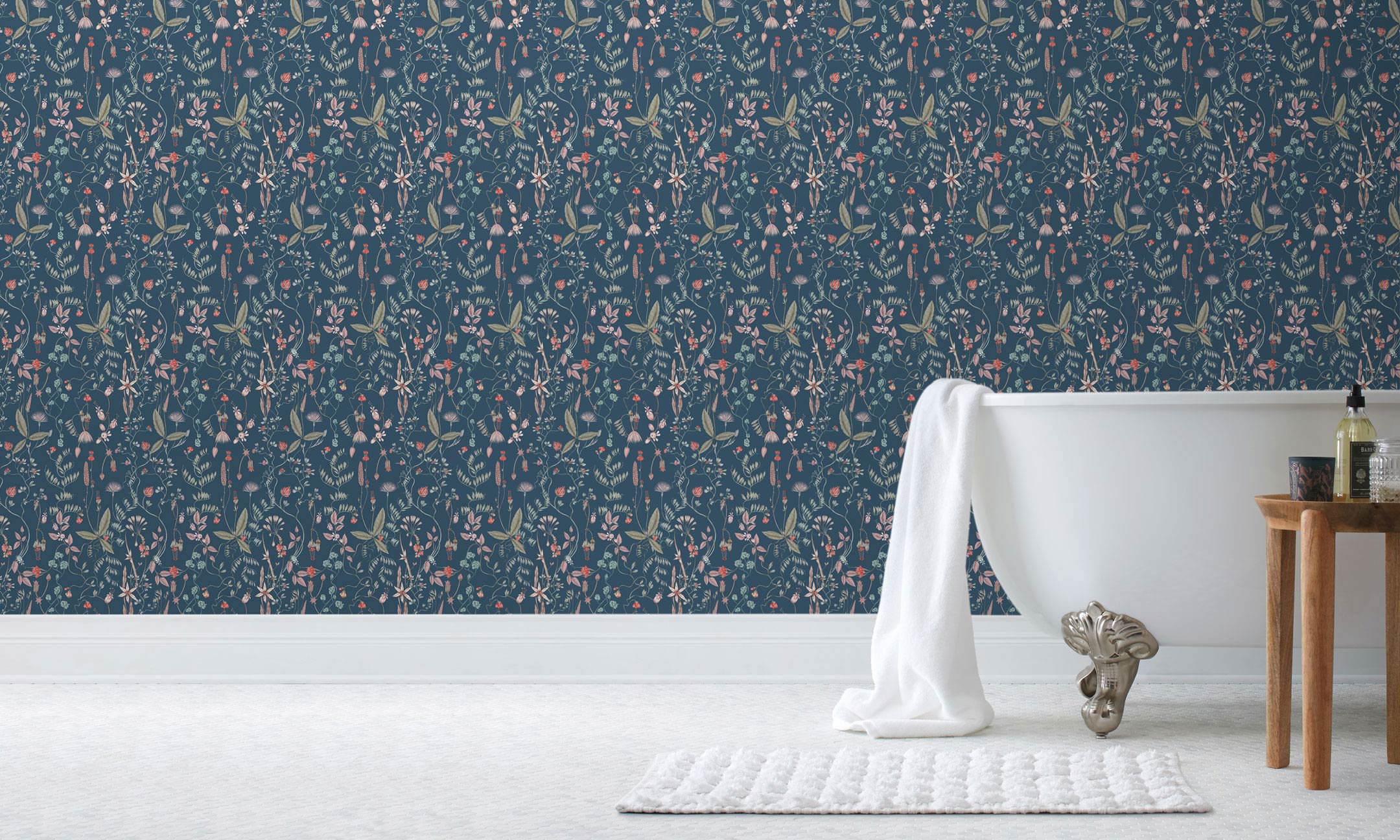 Sonoma (Indigo) wallpaper with green, mauve, coral and pink flowers and leaves on a blue background